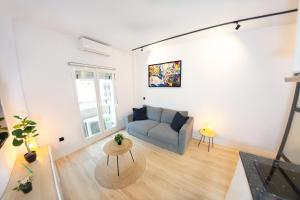 a living room with a couch and a tv at 31 Apartments - Luxe in het centrum van Malaga in Málaga