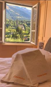 uma cama com uma janela com vista para uma montanha em Casa Dorino - Casa di vacanza ideale per famiglie em Rodi