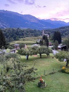 a green field with trees and mountains in the background at Casa Dorino - Casa di vacanza ideale per famiglie in Rodi