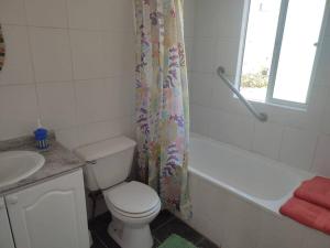 a bathroom with a toilet and a tub and a sink at Casa Mamalluca in Vicuña