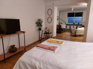 1 dormitorio con 1 cama blanca y TV de pantalla plana en Chatelain Residence, en Bruselas