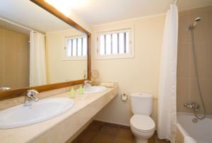 ein Badezimmer mit zwei Waschbecken und einer Toilette und einem Spiegel in der Unterkunft Miguel, 3 bed with private pool in Puerto del Carmen + 8 Fotos
