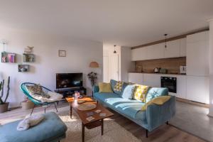 a living room with a blue couch and a table at Appartement très calme, terrasse & jardin en ville in Besançon