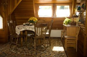 a dining room with a table and chairs at Dom w Szczyrku - stylowy drewniany dom z kominkiem in Szczyrk +9 photos
