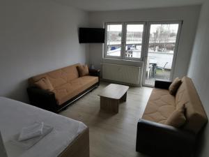 a living room with two couches and a table at Ferdimesse Apartments 2 in Cologne