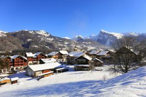 uma aldeia na neve com montanhas ao fundo em Grand Morillon - 104 - Montagne Belle Vue Studio 4 em Morillon