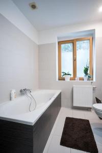 Un baño blanco con bañera y inodoro. en Dom z ogrodem blisko centrum, en Poznan 13 fotos más