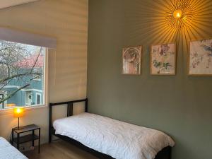 een slaapkamer met 2 bedden en een raam en een lamp bij Lovely family house nearby Amsterdam and Schiphol in Almere