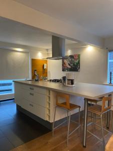 a kitchen with a counter with two chairs and a table at Lovely family house nearby Amsterdam and Schiphol in Almere