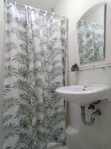 a bathroom with a sink and a shower curtain at 2BR Casa Mia Sanremo Oasis Cebu in Talisay