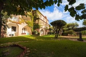 a large house with a green lawn in front of it at Residence La Rosa in Porto San Paolo
