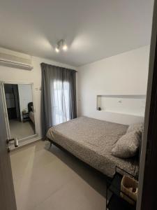 a bedroom with a bed and a large window at Casaki38 in Heraklio
