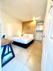een kleine slaapkamer met een bed en een tafel bij UDEE Cozy Hotel in Chiang Mai