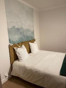 a white bed with two pillows on top of it at Une escapade au cœur d'Annecy in Annecy