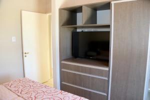 1 dormitorio con armario y TV. en Complejo Turístico Natuel en Vista Flores
