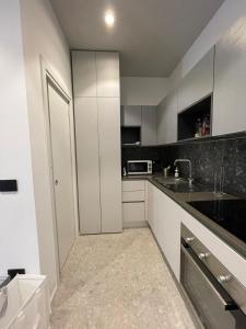 a kitchen with white cabinets and black counter tops at De Luca 6 Apartments in Salerno