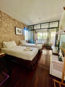 una camera d'albergo con due letti e una finestra di UDEE Cozy Hotel a Chiang Mai