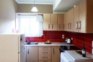 uma cozinha com um frigorífico branco e azulejos vermelhos em Despina's House em Nydri