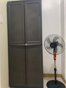 マニラにあるDeluxe Room South Residencesの扇風機、黒いキャビネット