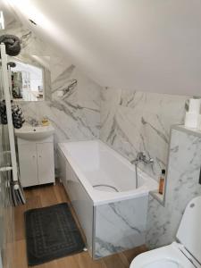 biała łazienka z wanną i umywalką w obiekcie Dach nad głową w Szczecinku