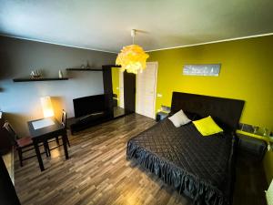 Prima Residence Apartment في أوراديا: غرفة نوم بسرير وجدار اصفر