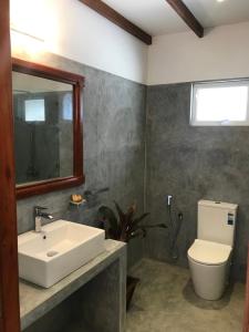 y baño con lavabo, aseo y espejo. en Bali Villa Mirissa, en Mirissa