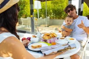 een gezin dat aan een tafel zit en ontbijt eet bij Hotel Tiffany & Resort in Cesenatico