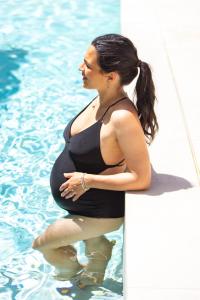 a pregnant woman is standing in the water at Hotel Tiffany & Resort in Cesenatico