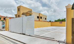 a gate in a parking lot in front of a building at Premium Single Room in Corales del Sur in La Viva