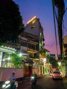 two people riding motorcycles down a street at night at LEHA Saigon Hotel Airport in Ho Chi Minh City