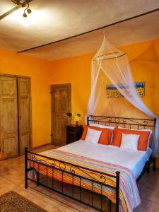 - une chambre avec un lit et des oreillers orange dans l'établissement A casa di Anna, à Vaglio Serra