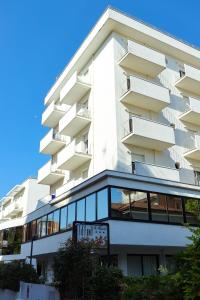 a tall white building with a sign in front of it at Hotel Tiffany & Resort in Cesenatico