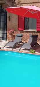 - deux chaises et un parasol à côté de la piscine dans l'établissement A casa di Anna, à Vaglio Serra