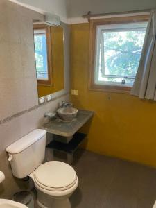 baño con aseo y lavabo y ventana en Cabaña Bariloche Lodge 2 en San Carlos de Bariloche
