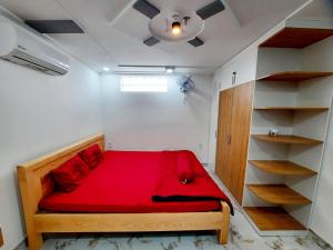 een slaapkamer met een rood bed in een kamer bij MM's House in Ho Chi Minh-stad