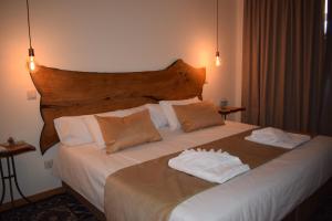 a hotel room with a bed with two towels on it at Afonsos House & Rooms in Videmonte