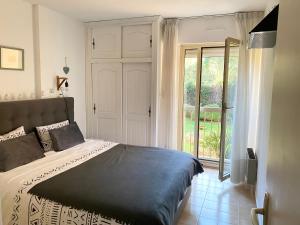 sypialnia z łóżkiem i przesuwanymi drzwiami szklanymi w obiekcie Golfe Juan, quiet apartment with pool, near the beach w mieście Vallauris