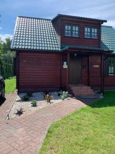 una piccola casa rossa con tetto di gamberetti di Sielski domek Grzybowo a Grzybowo