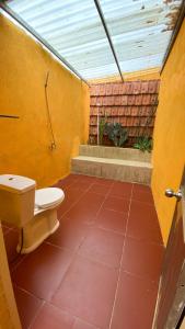 a bathroom with a toilet on a red tile floor at Nhà Ông Chú in Phước Bình