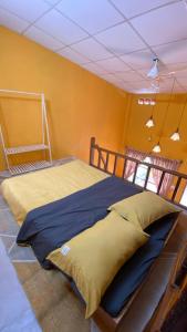 a large bed in a room with yellow walls at Nhà Ông Chú in Phước Bình