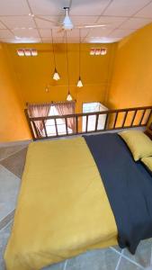 a large bed in a room with yellow walls at Nhà Ông Chú in Phước Bình