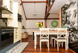 - une cuisine avec une table et des chaises blanches dans l'établissement Atelier / Guesthouse Arriën - De Studio van Slim, à Arriën