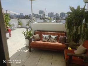 un sofá en la parte superior de un balcón con plantas en Habitación RRB, en Lima