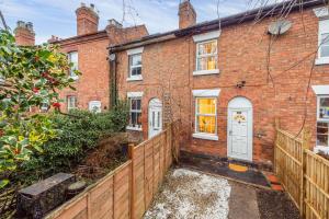 a brick house with a white door and a fence at Hereford Road Shrewsbury Cottage in Shrewsbury