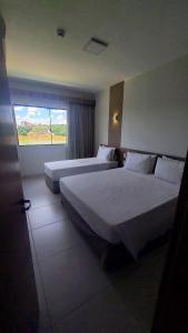 2 camas en una habitación de hotel con ventana en Resort Praias do Lago, en Caldas Novas