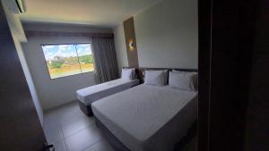 Habitación de hotel con 2 camas y ventana en Resort Praias do Lago, en Caldas Novas