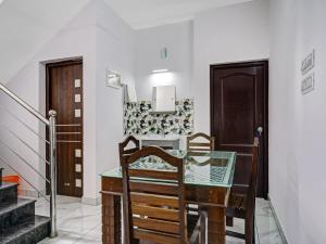 a dining room with a table and chairs and stairs at Shalom Palace Residency in Neriyamangalam