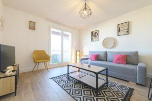 a living room with a couch and a table and a tv at Magnifique appartement T2 rénové Aux vendanges Gaillac in Gaillac