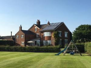 Chirk Cottage at Hill House Farm Cheshire في تاربورلي: ملعب أمام منزل كبير