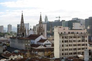 Centro da cidade com vista para o Cristo في ريو دي جانيرو: اطلالة على مدينة بها كنائس ومباني